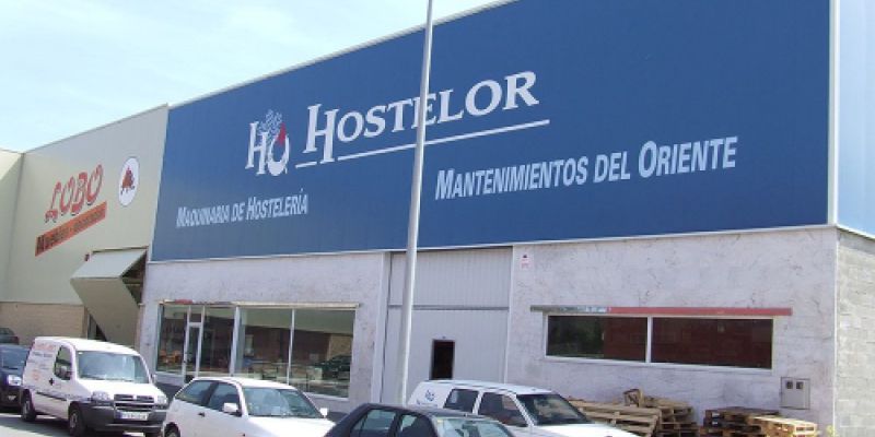 Nave de Hostelor con rótulo azul y aparcamiento
